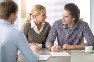 young-smiling-couple-about-to-sign-a-house-renting-agreement-happy-to-buy-new-apartment-meeting-in-the-office-with-a-trusted-reliable-real-estate-agent-confident-in-credit