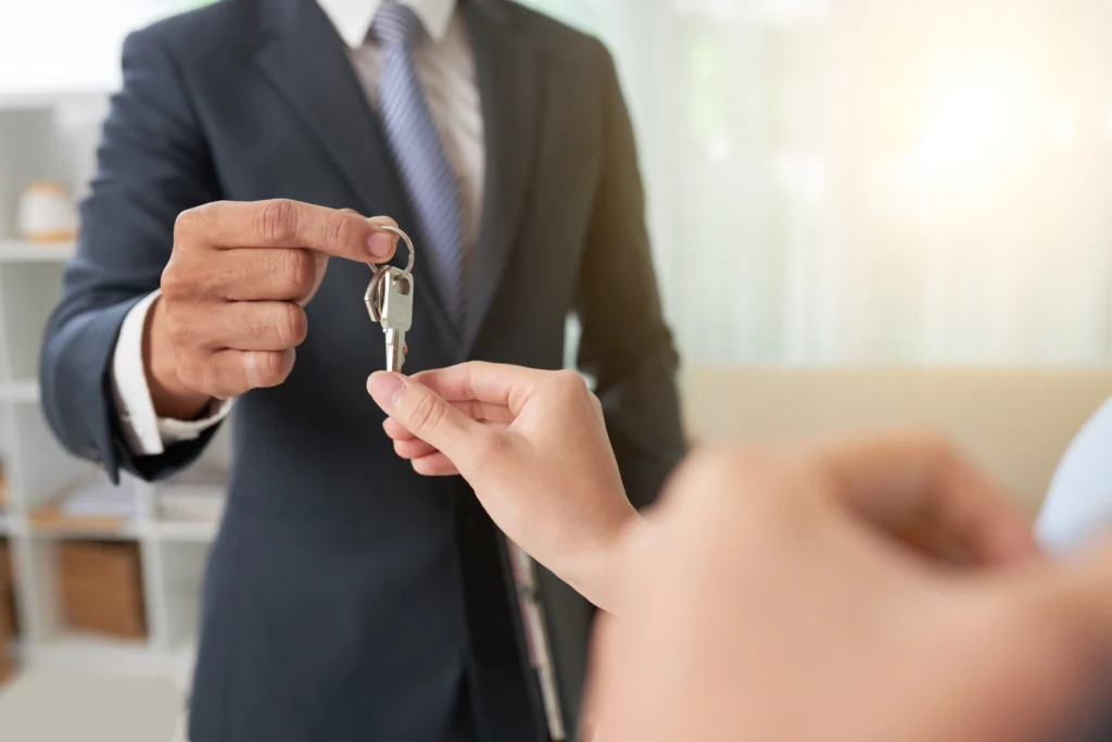 hand-of-woman-taking-keys-from-hand-of-real-estate-owner-scaled