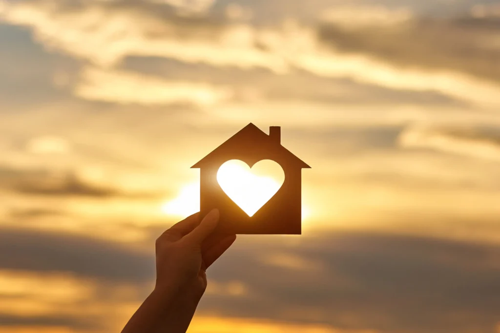 woman-hand-holds-wooden-house-in-the-form