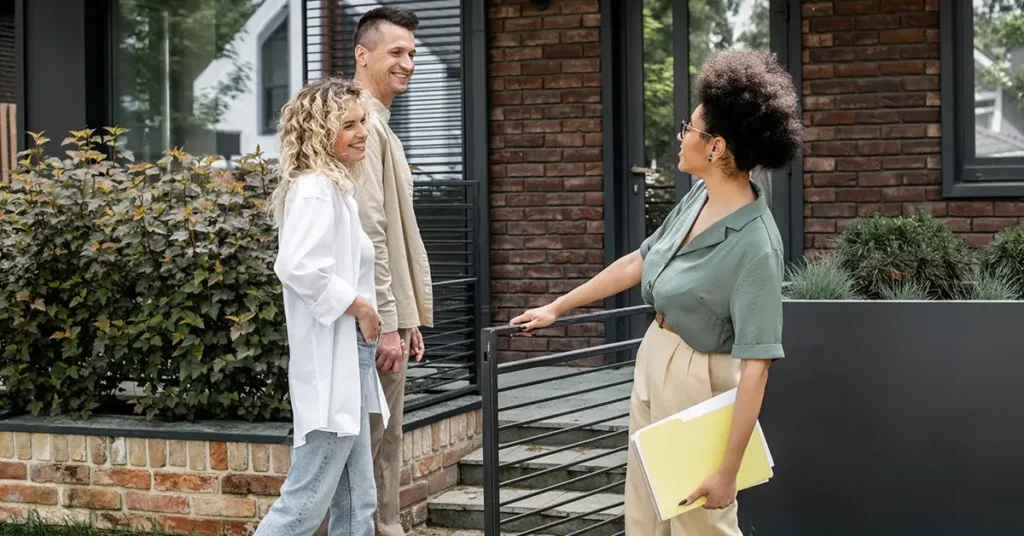 A young couple entering a potential rental property with the property manager.