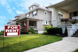 A "for rent" sale is on display in the manicured front lawn of a house.