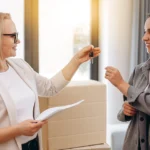 Realtor agent giving a key of apartment to new owner after signed lease agreement.