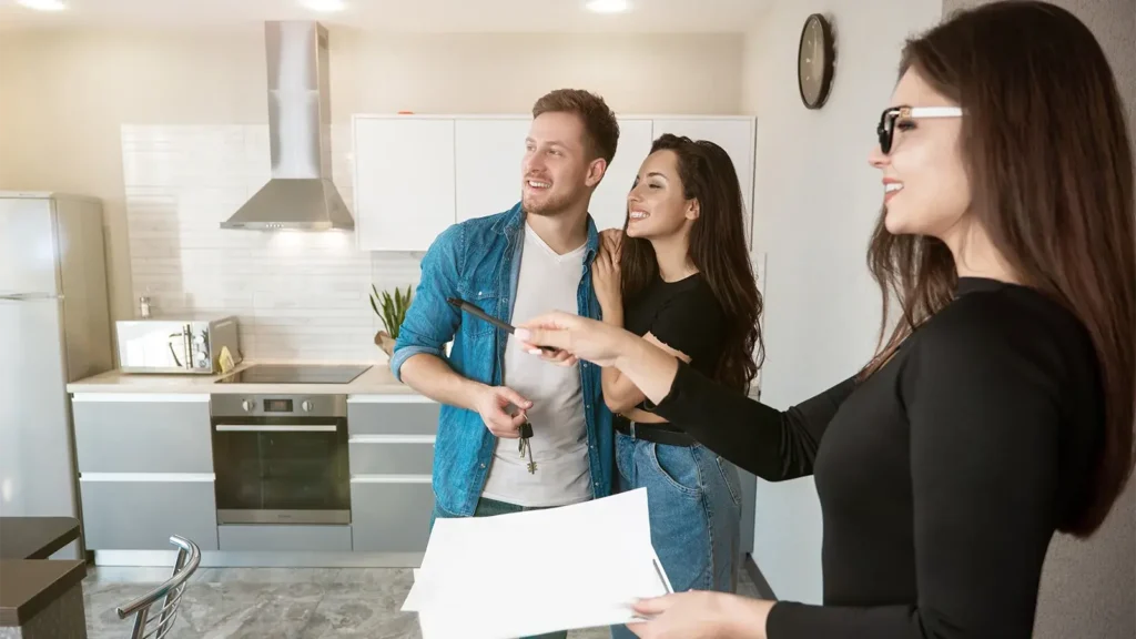 woman realtor property manager showing new apartment for rent to young couple