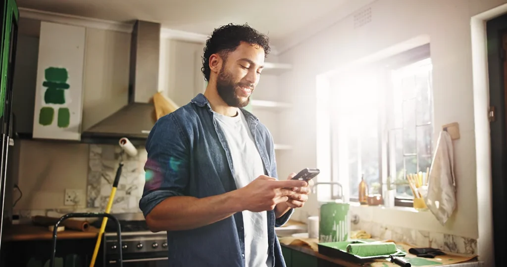 Man in kitchen of apartment to search for home improvement ideas.