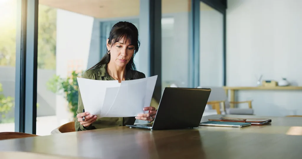 Business, woman and document with laptop at house for real estate, property report and contract.