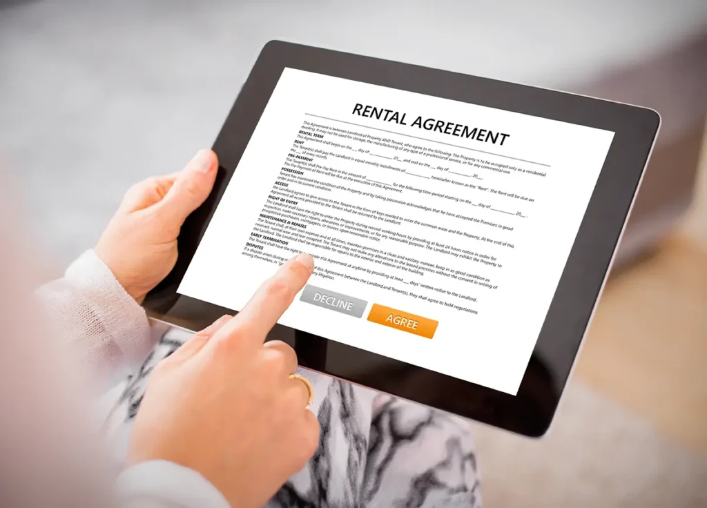 A person holding a tablet with a lease agreement on the screen, using their finger to read over the copy