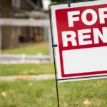 For rent sign in the yard in front of a house